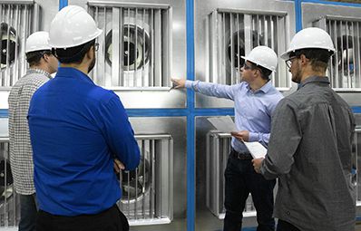 Workers inspect an array of fans